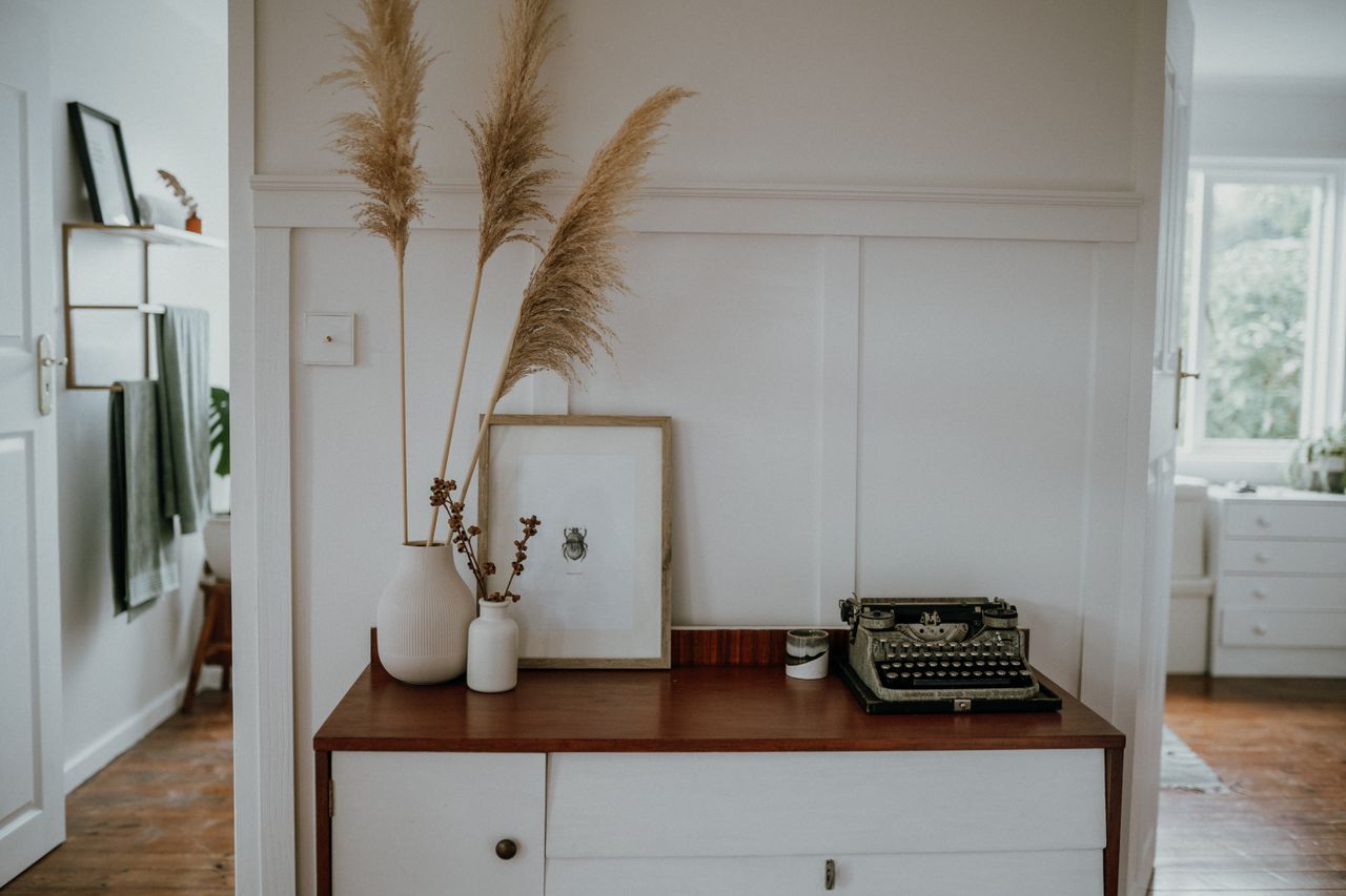 Elegant Scandinavian interior with pampas grass and vintage typewriter decor.